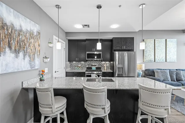 a kitchen with a dining table chairs sink and granite counter top