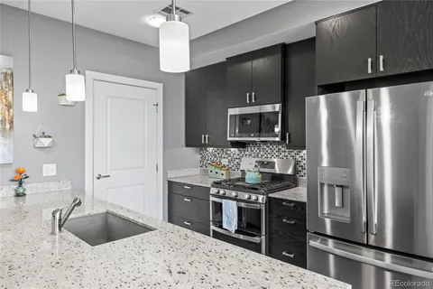 a kitchen with stainless steel appliances a sink stove and refrigerator