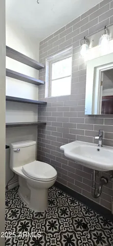 a bathroom with a sink a toilet and a mirror