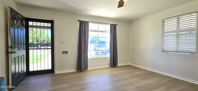 a view of an empty room with glass door and balcony