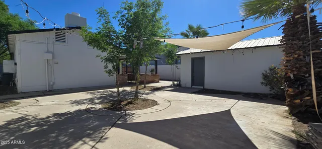 a backyard of a house with table and chairs with wooden fence