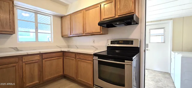 a kitchen with cabinets appliances a sink and a window