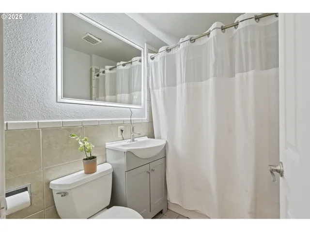a bathroom with a sink a toilet and a mirror