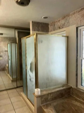 a bathroom with a shower and a mirror
