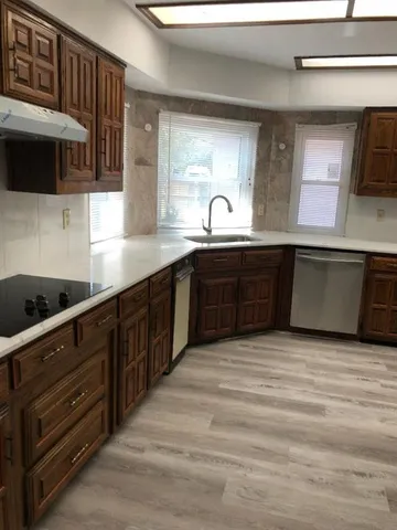a kitchen with stainless steel appliances granite countertop a sink and a stove
