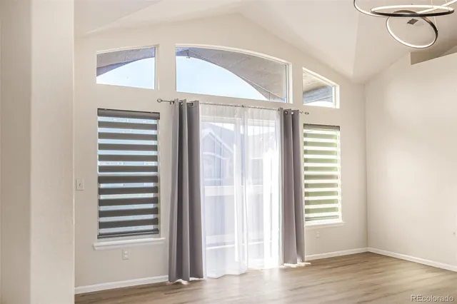 a view of a bedroom with wooden floor and windows