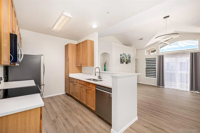 a kitchen with stainless steel appliances kitchen island granite countertop a sink stove and refrigerator