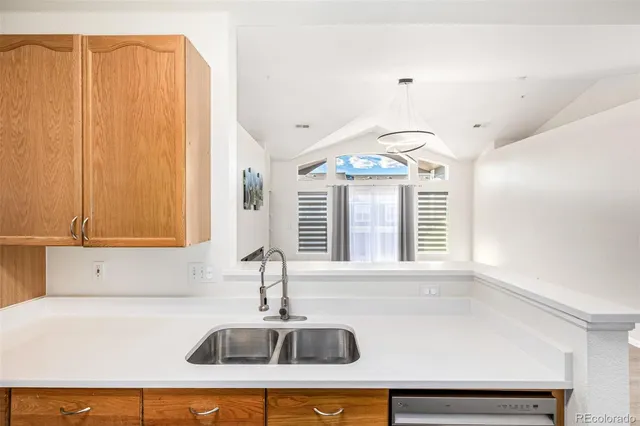 a kitchen with a sink a window and chandelier