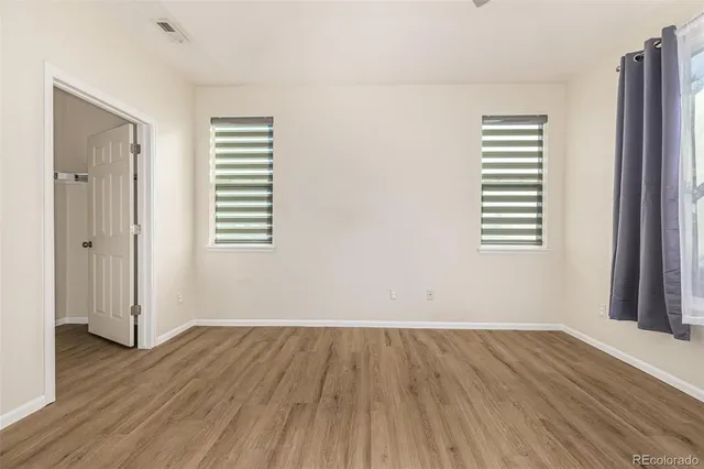 an empty room with wooden floor and a window