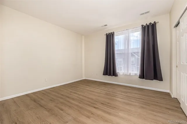 an empty room with wooden floor and a window