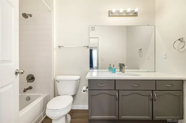 a bathroom with a granite countertop toilet sink and mirror