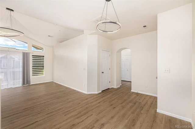 a view of empty room with wooden floor and window