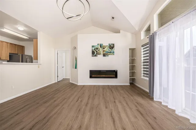 a view of a livingroom with wooden floor and a ceiling fan