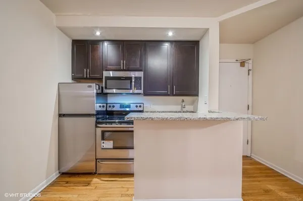 a kitchen with kitchen island granite countertop cabinets and steel stainless steel appliances