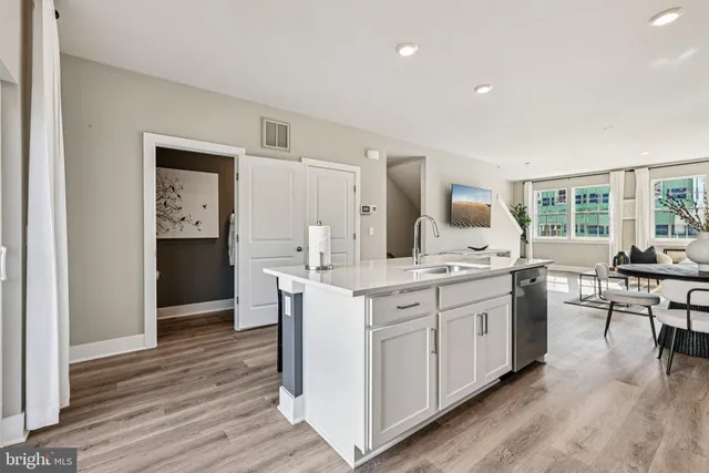a kitchen with white cabinets and sink