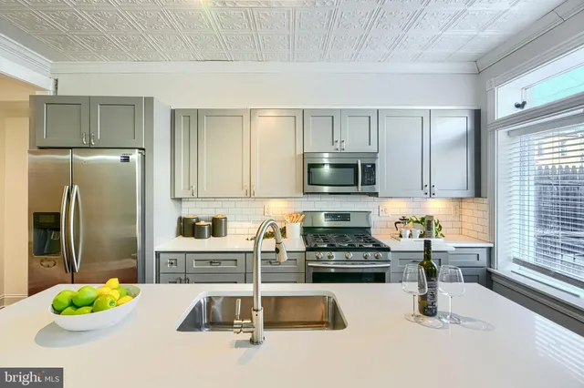a kitchen with stainless steel appliances a stove sink microwave and cabinets