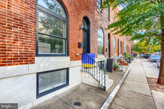 a front view of a house with a tree