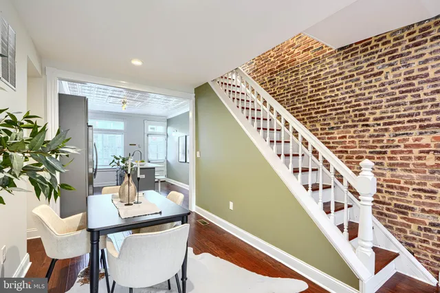 a kitchen with a refrigerator a stove a sink and dishwasher with wooden floor