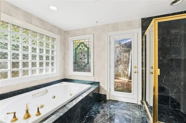 a spacious bathroom with a tub shower and sink
