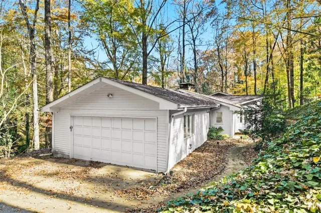 front view of house with a yard and trees
