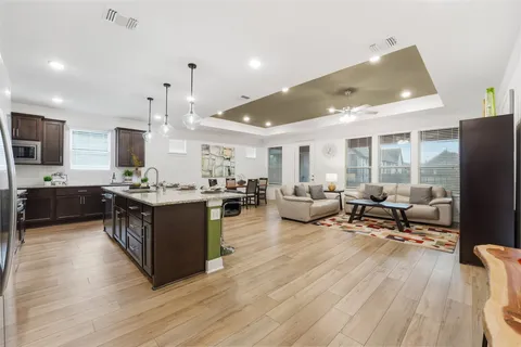 a kitchen with a stove a refrigerator a sink and chairs