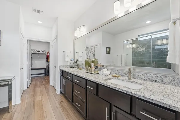 a spacious bathroom with a granite countertop sink a mirror and shower