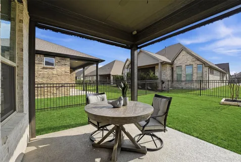 a backyard of a house with table and chairs