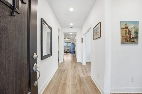 a view of a hallway with wooden floor and staircase