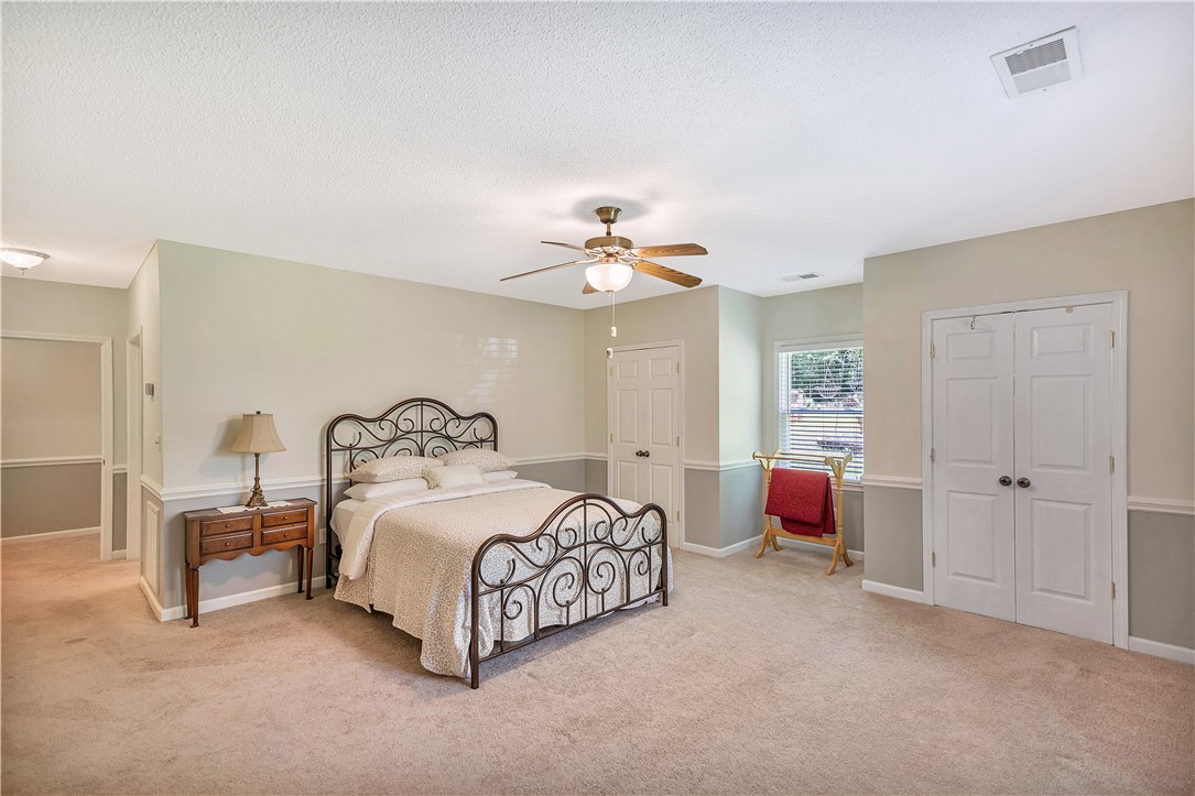 910 Chantilly Lane Anderson, SC 29625 - Photo 14 of 38 A comfortable bedroom boasts carpet flooring and a refreshing ceiling fan.