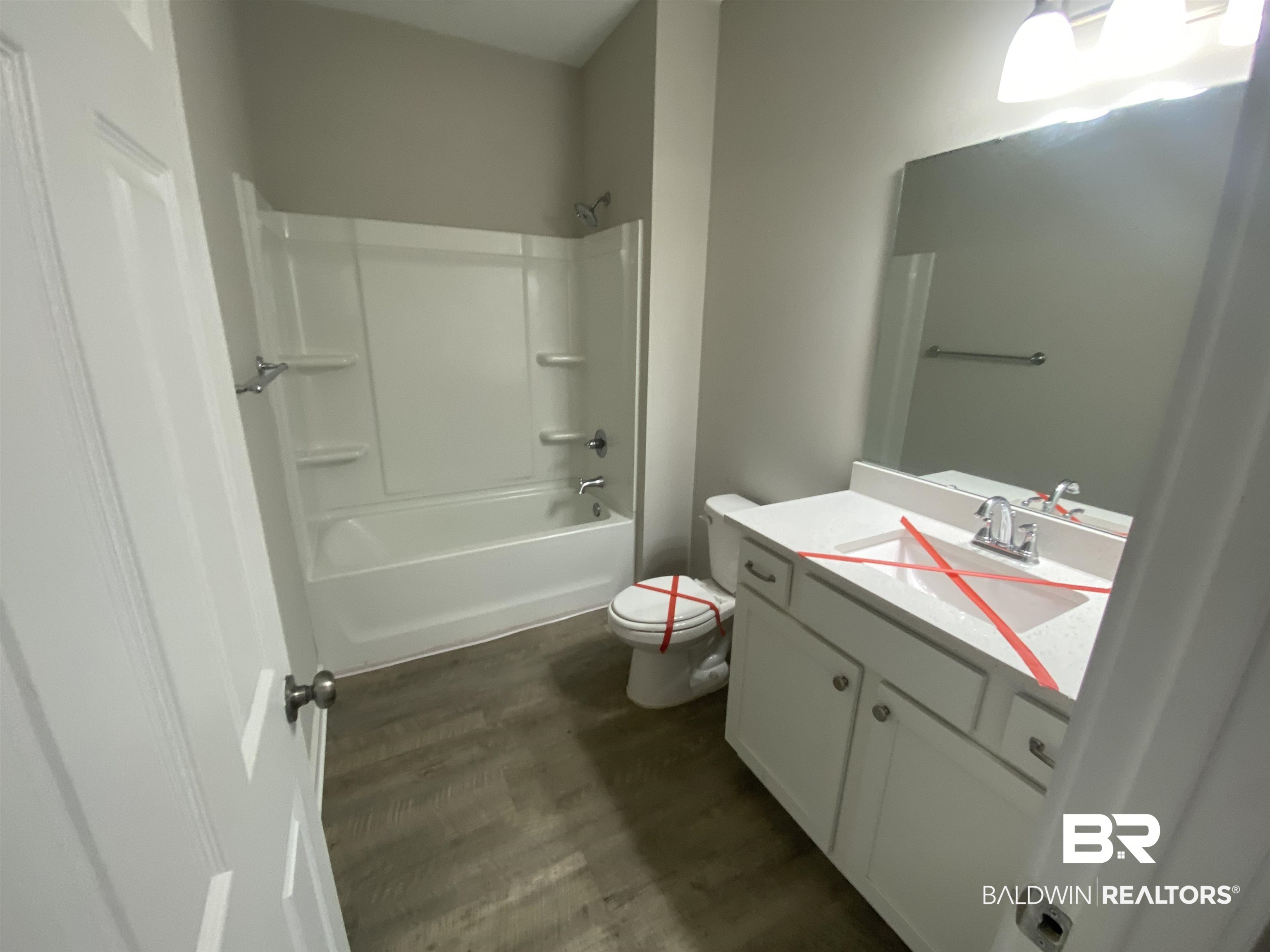 1279 Cater Lee Way Foley, AL 36535 - Photo 3 of 12 Full bathroom featuring washtub / shower combination, hardwood / wood-style floors, vanity, and toilet