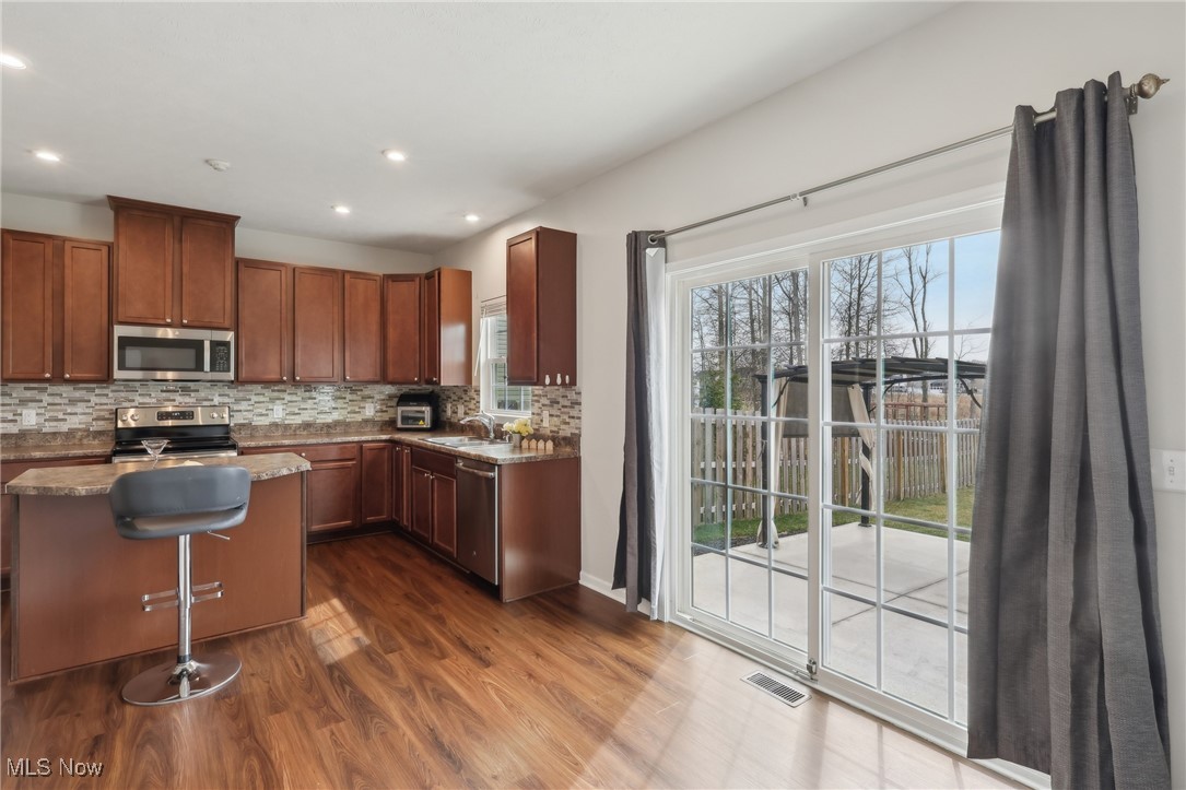 257 Stone Ridge Way Berea, OH 44017 - Photo 4 of 20 Kitchen featuring decorative backsplash, appliances with stainless steel finishes, dark wood finished floors, and a healthy amount of sunlight
