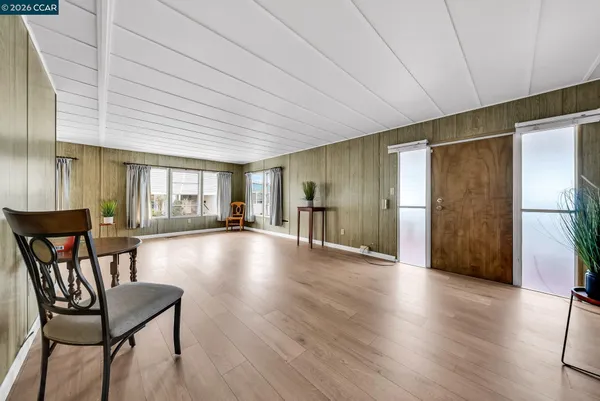 a view of a living room hardwood floor and a kitchen