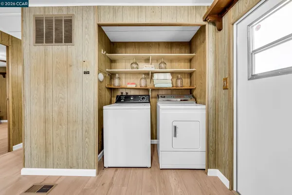 a view of a livingroom with a chandelier fan and windows