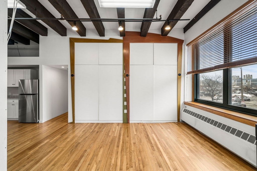 259 A Street, Unit 21 Boston, MA 02210 - Photo 5 of 18 a view of a room with wooden floor and windows