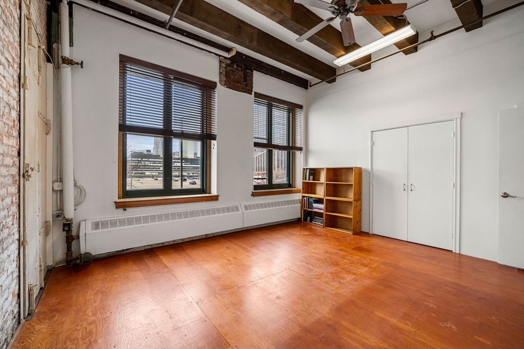 259 A Street, Unit 21 Boston, MA 02210 - Photo 9 of 18 an empty room with wooden floor and windows