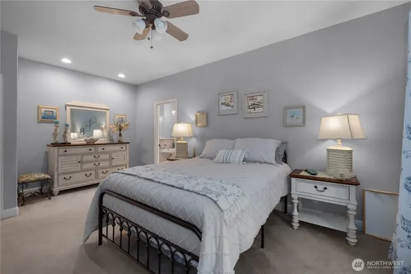 a bedroom with a bed a lamp and fan