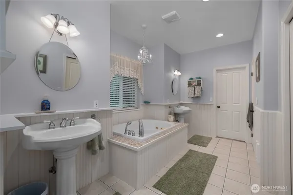 a bathroom with a bathtub a sink and a mirror