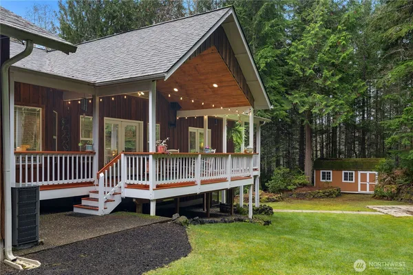 a view of house with a yard and deck area