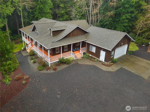 a aerial view of a house with a yard and large tree