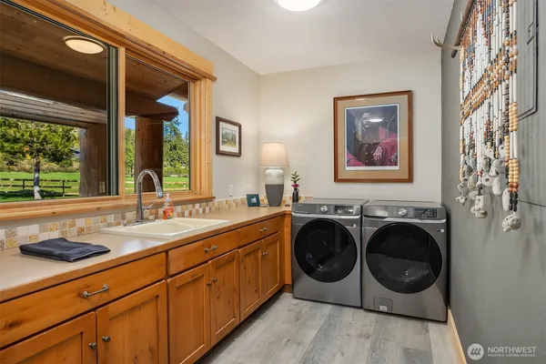 a utility room with stainless steel appliances a sink and a window
