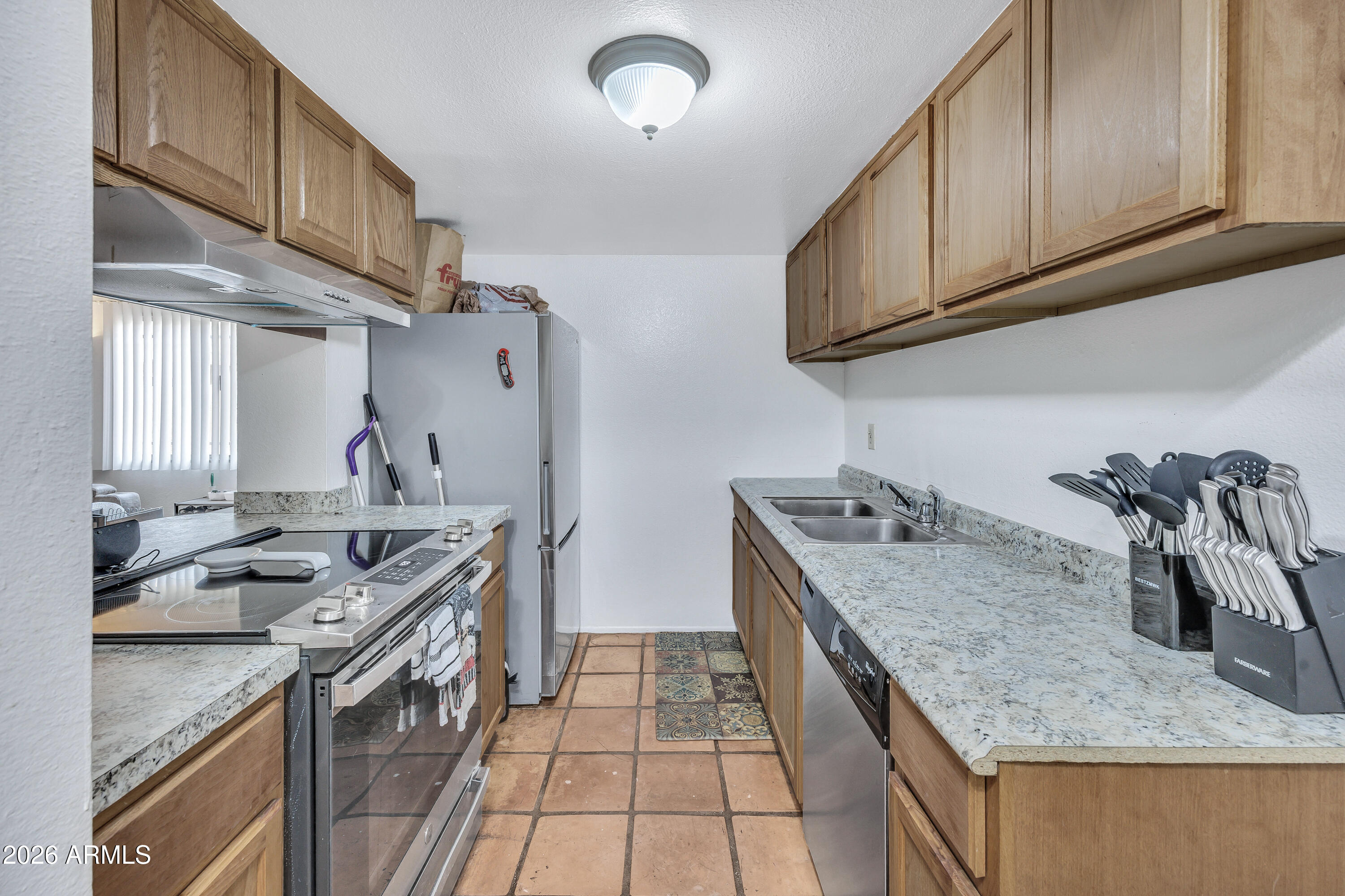 4604 East Riverside Street Phoenix, AZ 85040 - Photo 11 of 24 a kitchen with stainless steel appliances granite countertop a sink stove and refrigerator