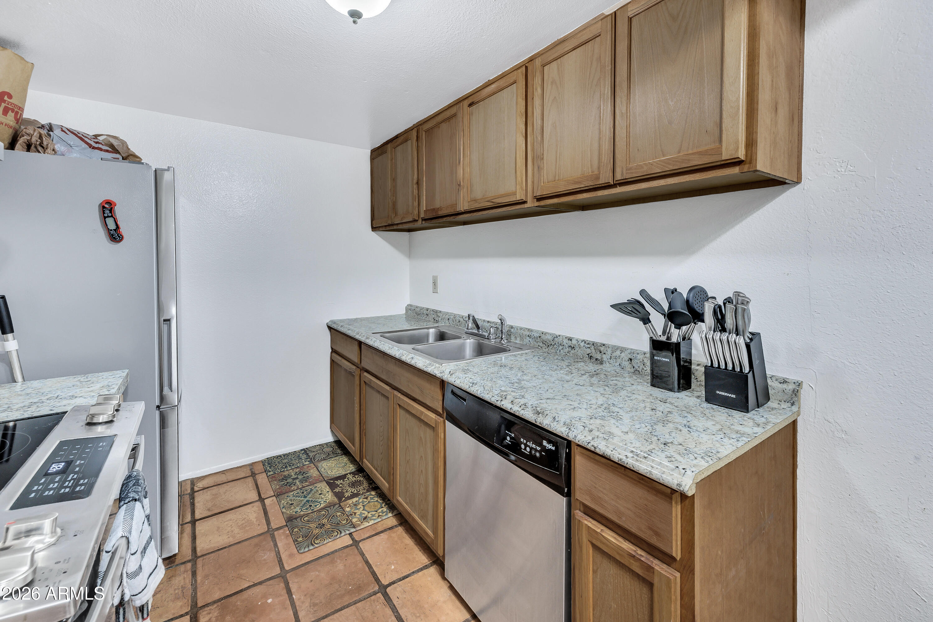 4604 East Riverside Street Phoenix, AZ 85040 - Photo 12 of 24 a kitchen with granite countertop a sink a stove and a microwave