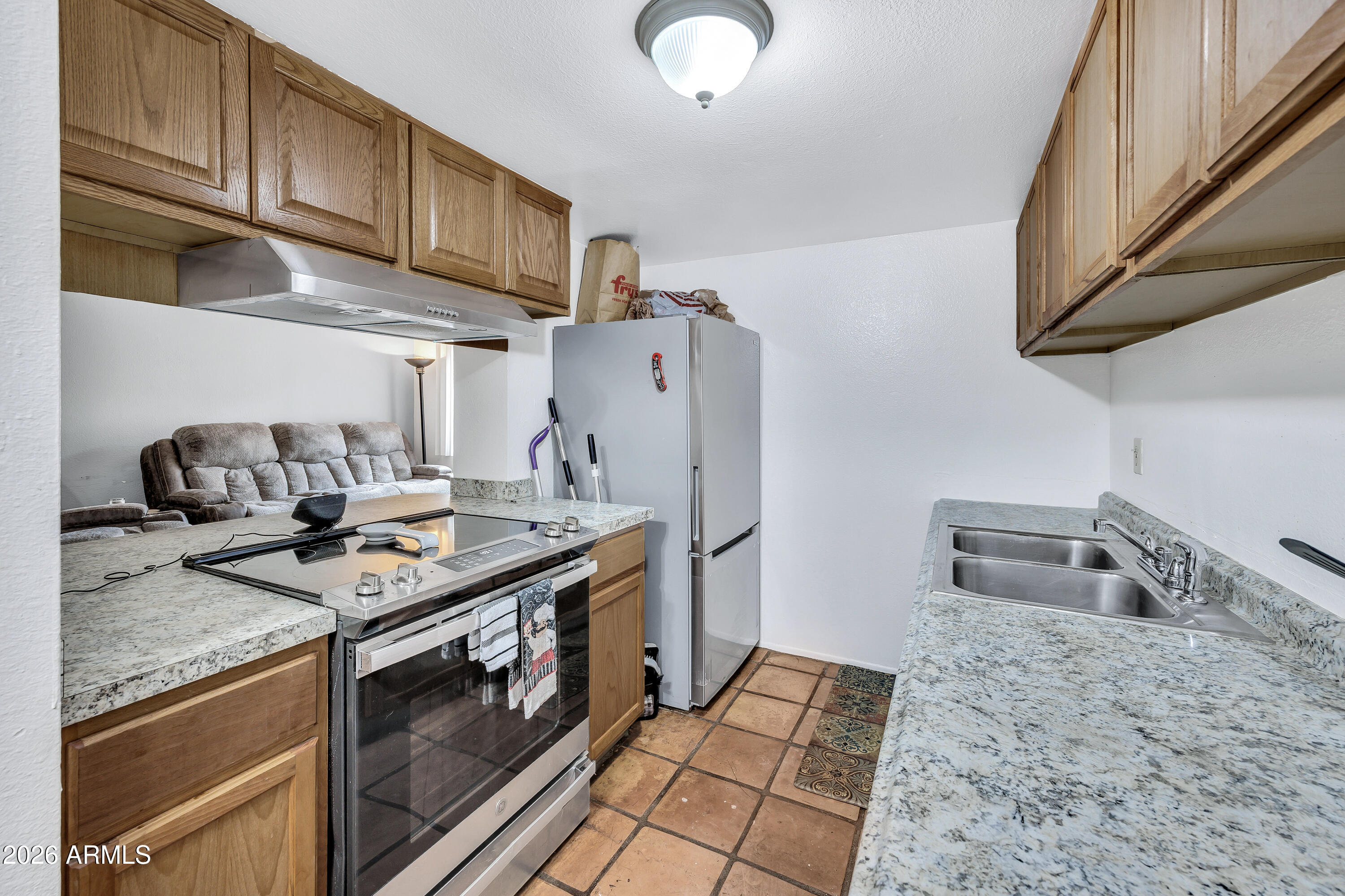 4604 East Riverside Street Phoenix, AZ 85040 - Photo 13 of 24 a kitchen with stainless steel appliances granite countertop a sink stove and refrigerator