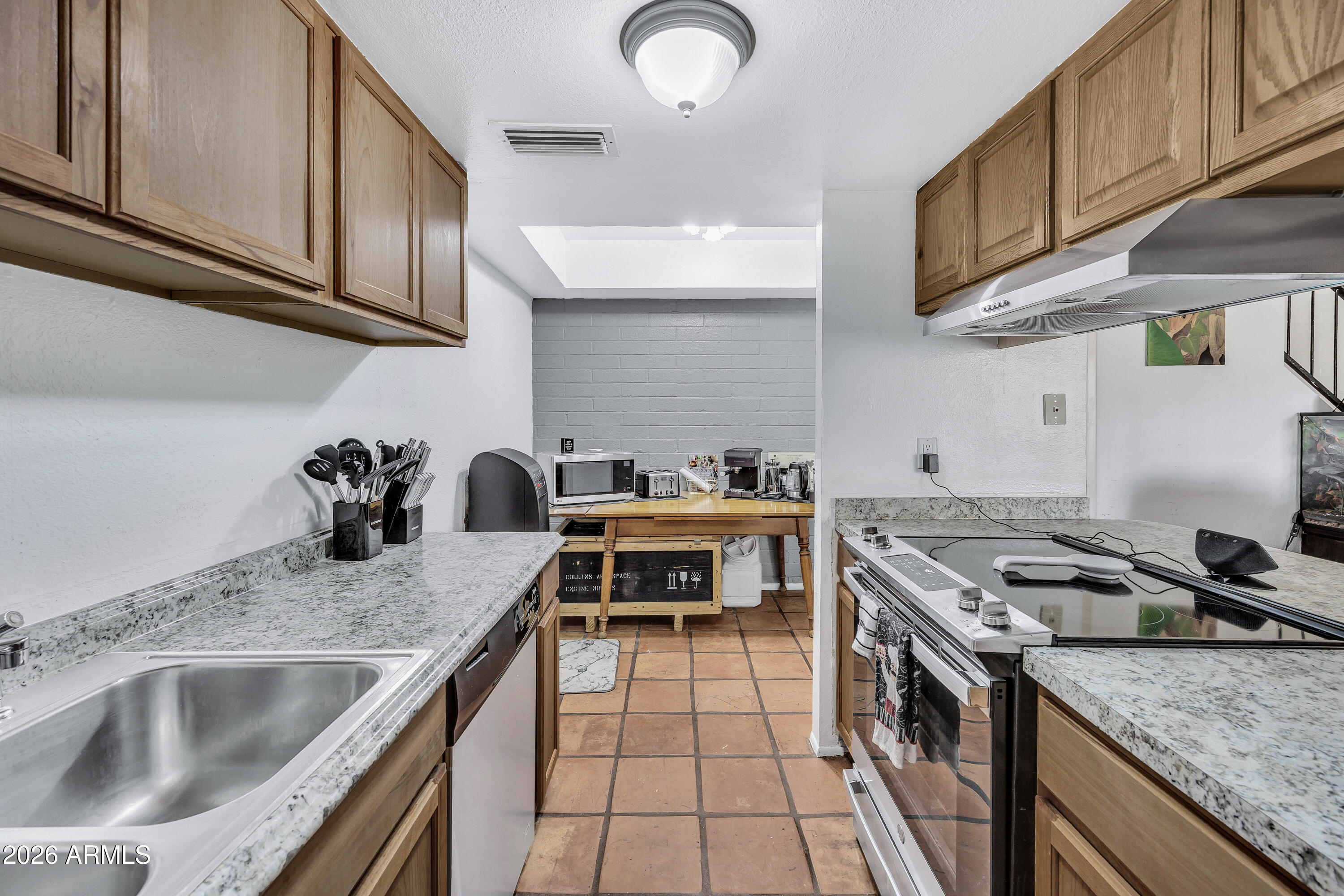 4604 East Riverside Street Phoenix, AZ 85040 - Photo 14 of 24 a kitchen with granite countertop a stove and a sink