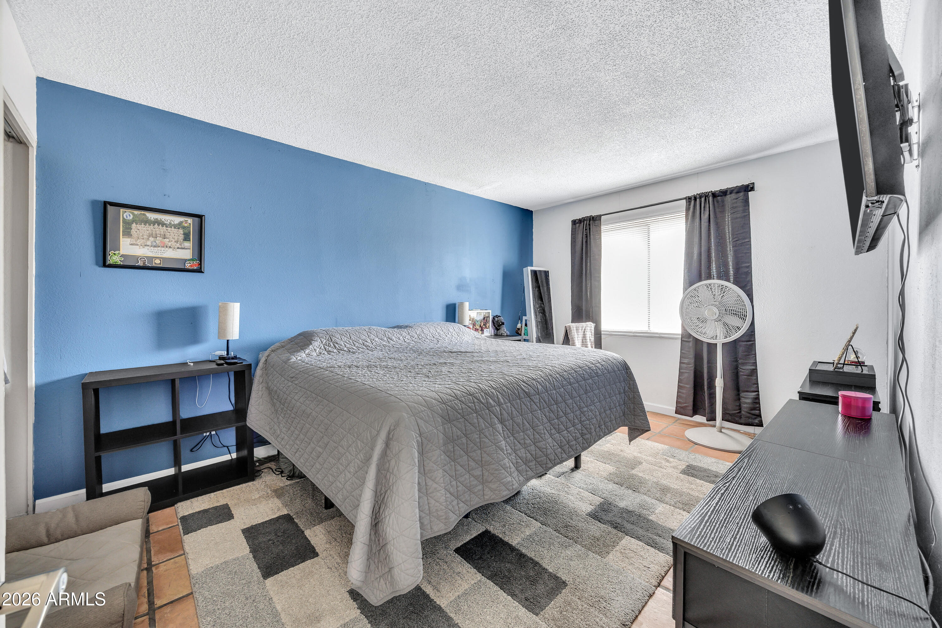 4604 East Riverside Street Phoenix, AZ 85040 - Photo 17 of 24 a bedroom with a bed and a table in it