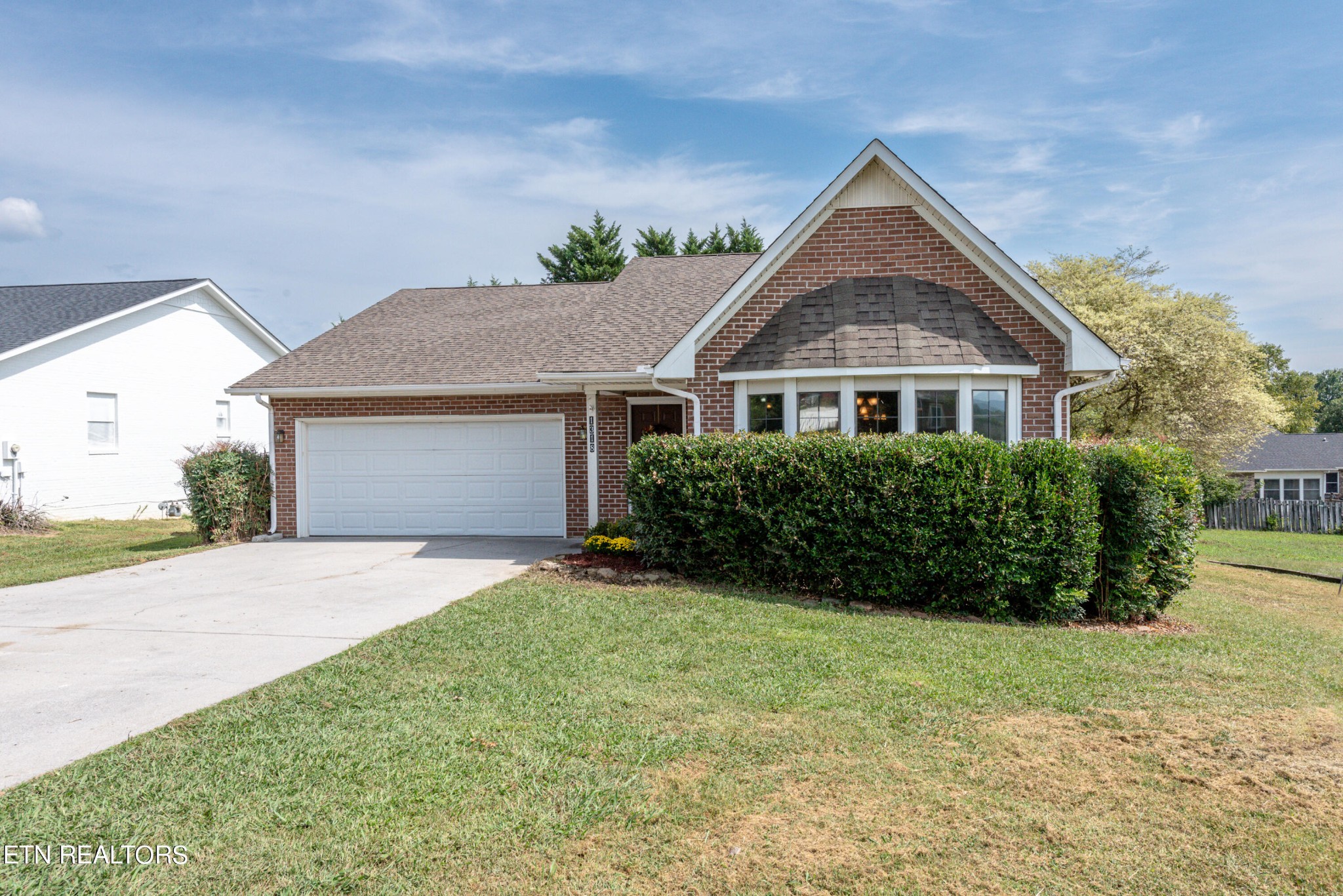 a front view of a house with a garden and yard