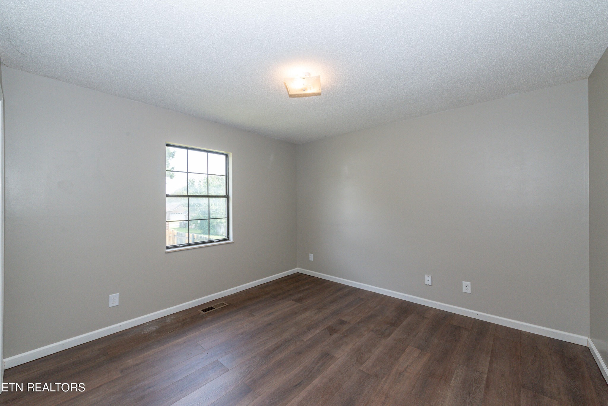 1318 Raulston Road Maryville, TN 37803 - Photo 18 of 28 an empty room with wooden floor and windows