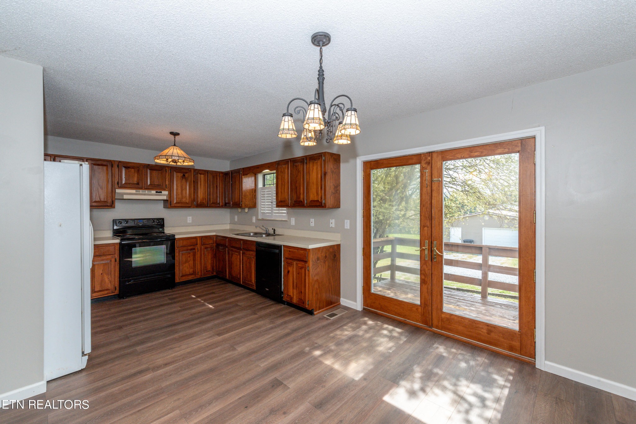 1318 Raulston Road Maryville, TN 37803 - Photo 7 of 28 a kitchen with stainless steel appliances granite countertop a stove a sink dishwasher and a refrigerator with wooden floor