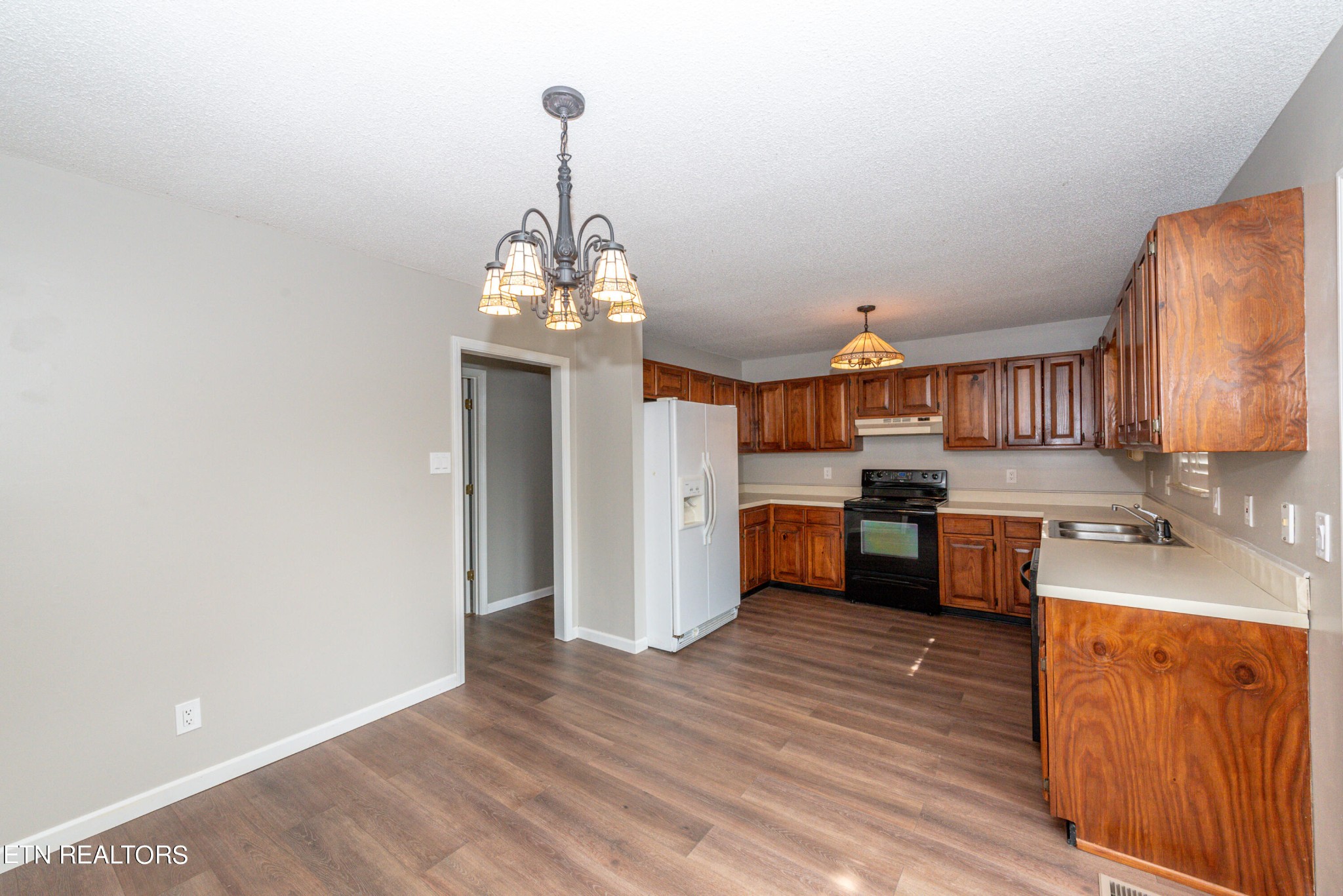 1318 Raulston Road Maryville, TN 37803 - Photo 8 of 28 a kitchen with stainless steel appliances granite countertop a sink dishwasher a stove and white countertops with wooden floor