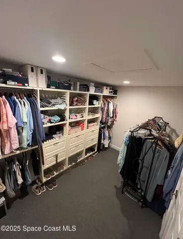 a view of walk in closet with clothes and shoes